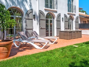 A modern outdoor patio with lounge chairs, a wicker table, and a potted plant. - Villas Odalys Collection Orée de Milady by Interhome (Biarritz)