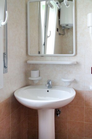 A bathroom with a white sink, a mirror, and a towel rack. - Le Farnie by Interhome (Caorle)