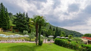 A resort with a pool area, lounge chairs, and umbrellas. - Corte Camaldoli by Interhome (Garda)