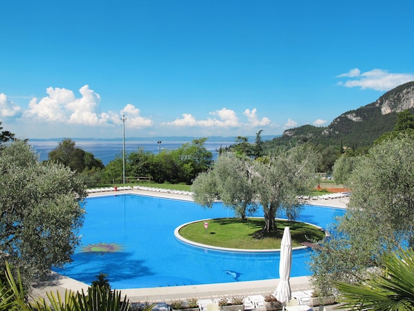 A swimming pool with a view of the sea and mountains.