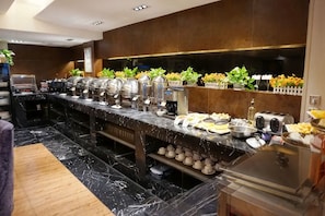 A buffet setup with various food items and a coffee station. - GREEN JOURNEY INN (Suzhou)