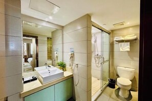 A modern bathroom with a large mirror, a sink, a shower, and a toilet. - Green Journey Inn (Suzhou)