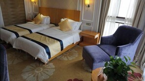 A hotel room with two beds, a nightstand, a chair, and a potted plant. - Green Journey Inn (Suzhou)