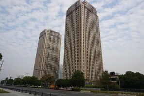 Two high-rise residential buildings with a clear sky and some clouds. - Green Journey Inn (Suzhou)