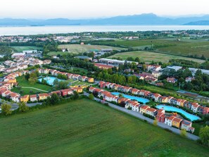 Zona residencial com piscina, casas e vista para um lago e montanhas.