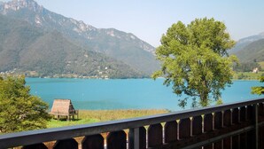 Un paysage de montagne avec un lac et une cabane au toit de chaume.