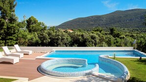 Une piscine avec des chaises longues et une vue sur une montagne.