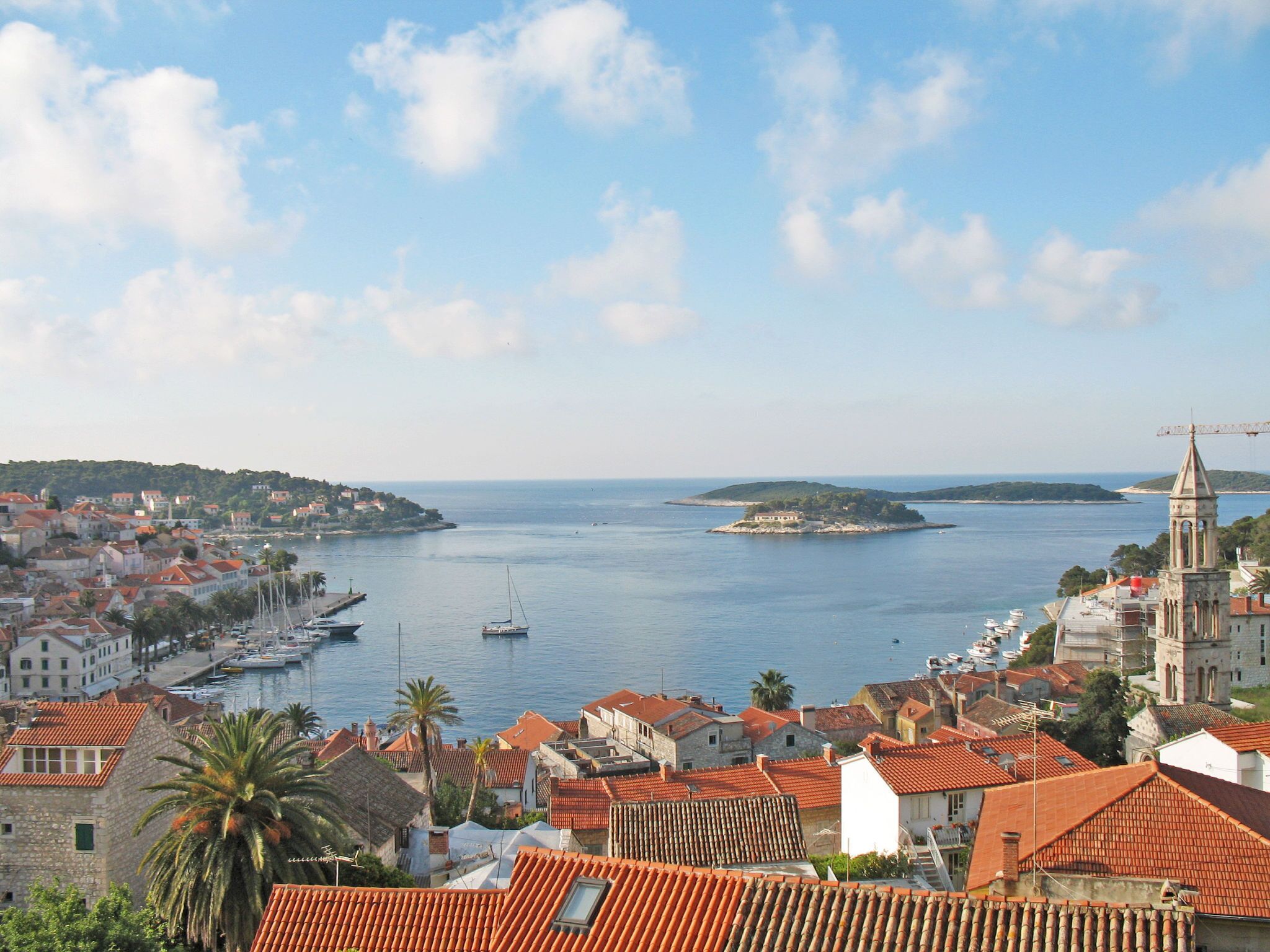 A coastal town with historic buildings, a marina, and a prominent church tower.