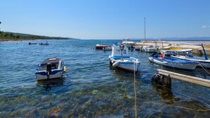 A marina with several boats docked, clear water, and a distant shoreline. - Apartment Mira by Interhome (Brač/Splitska)