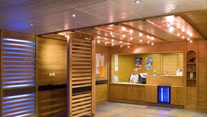 A reception area with a wooden interior, a reception desk, and a blue-lit partition. - Parc des Airelles by Interhome (Les Orres)