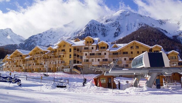 A snow-covered mountain resort with wooden lodges, ski lifts, and a clear view of the mountains. - Parc des Airelles by Interhome (Les Orres)