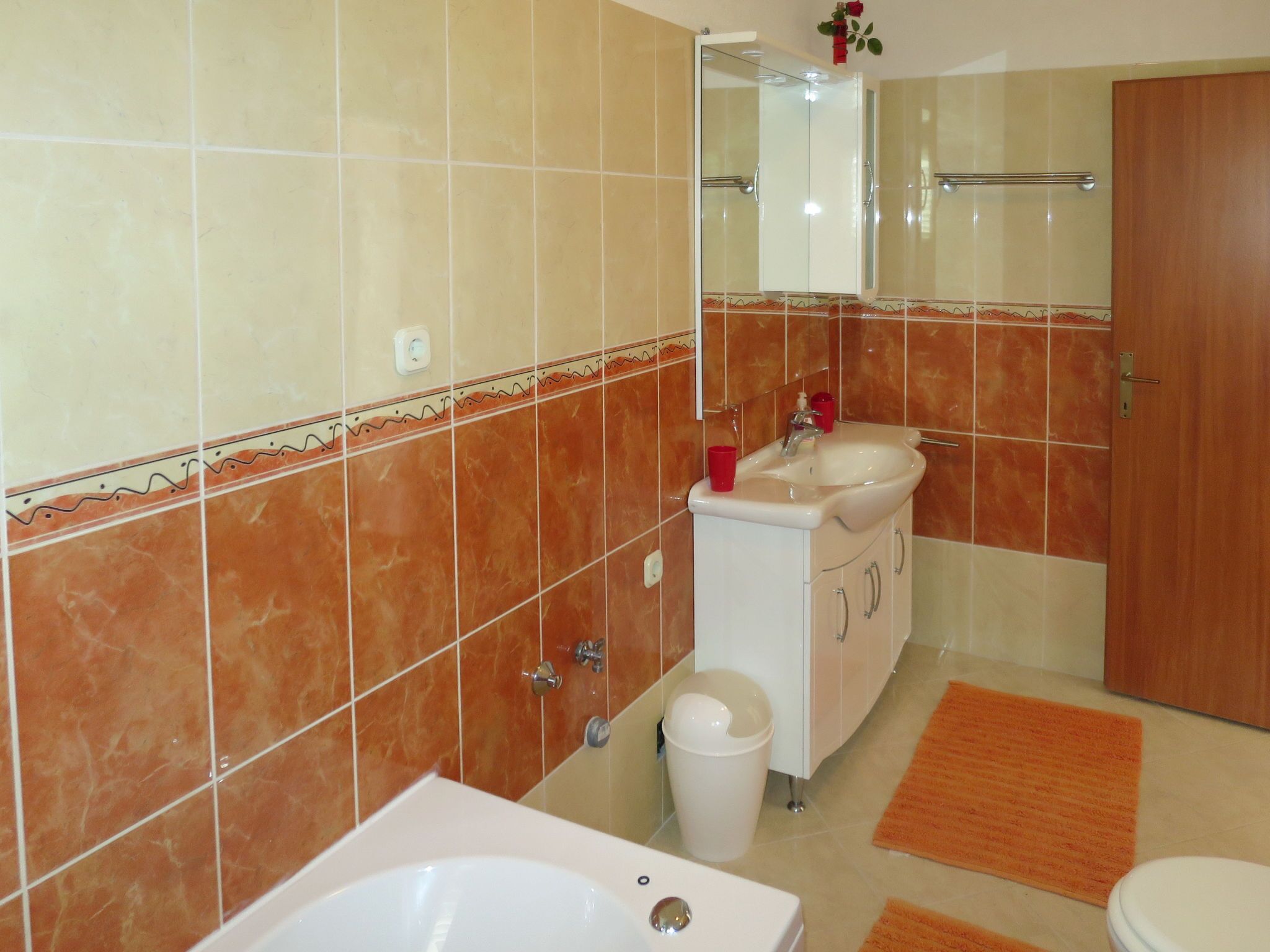 Een badkamer met een bad, wastafel en toilet.