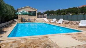 A swimming pool with lounge chairs, a stone building, and a green fence. - Camp Marko by Interhome (Rogoznica/Ražanj)