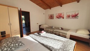 A bedroom with a wooden ceiling, a bed with floral-patterned bedding, a wardrobe, and a desk with a lamp. - Camp Marko by Interhome (Rogoznica/Ražanj)