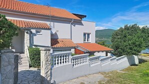 A two-story building with a tiled roof, stone steps, and a white fence. - Valentina by Interhome (Zadar)