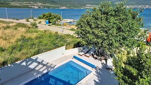 A pool area with a view of a lake and mountains, surrounded by greenery and a clear sky. - Valentina by Interhome (Zadar)