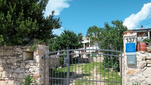 A gated entrance with a stone wall and a blue sign indicating the property number 137.
