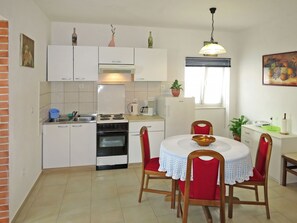 Enjoy cooking in this well-equipped kitchen with a central island, stove, oven, and sink. Dine at the adjacent table with comfortable seating.