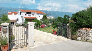 A white villa with a red-tiled roof, a stone gate, and a stone wall. - Apartment Lukeni by Interhome (Vinjerac)