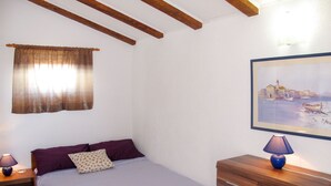 A bedroom with a bed, a nightstand, a dresser, a painting, and a window with curtains. - Apartment Lukeni by Interhome (Vinjerac)