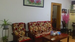 A living room with two floral-patterned sofas, a wooden coffee table, and a framed artwork on the wall. - 365 Boutique Inn (Kunshan)