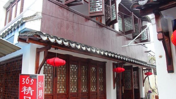 A traditional building with wooden doors and windows, a red lantern, and a sign with numbers. - 365 Boutique Inn (Kunshan)