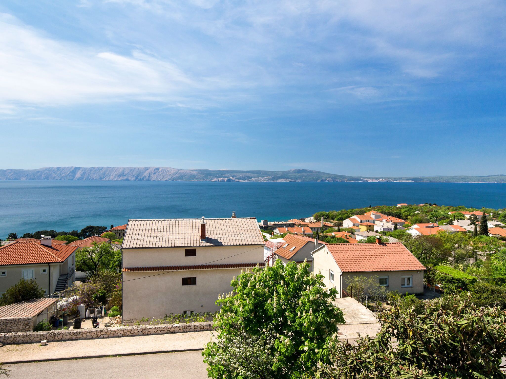 A coastal village with traditional Mediterranean architecture, including terracotta-tiled roofs and stone walls.