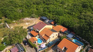 Un quartier résidentiel avec des maisons, une piscine et une vue sur la mer.