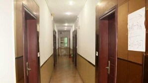 A hotel corridor with doors, a sign with room numbers, and a tiled floor. - Foshan Meek Hotel (Flatland Cloth Market Cowboy City) (Foshan)