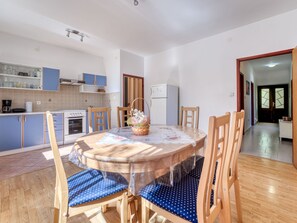 Una cocina con mesa, sillas y refrigerador.