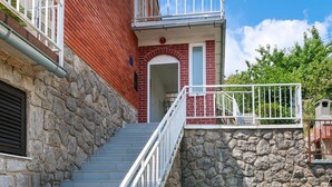 A staircase with stone walls and a red brick building. - Katarina by Interhome (Lovran)