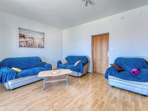 A room with two sofas, a coffee table, and a wooden floor.