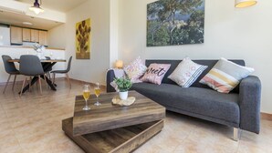 Una sala de estar moderna con sofá, mesa de centro y comedor.