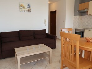 Cozy living space with a sofa, dining table, and kitchen area.