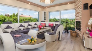 A modern living room with a sectional sofa, a glass coffee table, and a fireplace. - Villa Gabriel by Interhome (Labin)