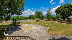 An outdoor sports court with a stone border, surrounded by trees and a clear sky. - Vacation home Diana by Interhome (Labin)