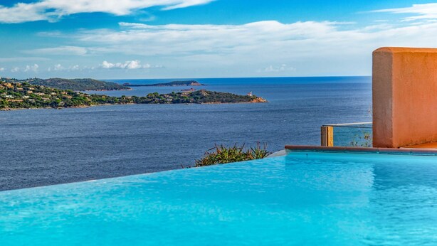 Ein Pool mit Blick auf das Meer und eine entfernte Insel.