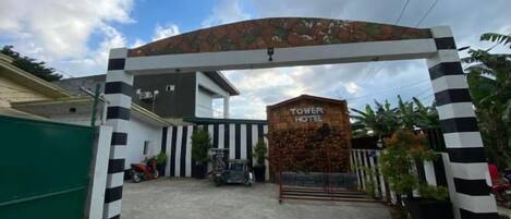A gated entrance to a hotel with a sign reading 'TOWER HOTEL'.