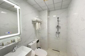 A modern bathroom with a white sink, toilet, and shower. - Orchid Smart Theme Hotel (Qiaojia)
