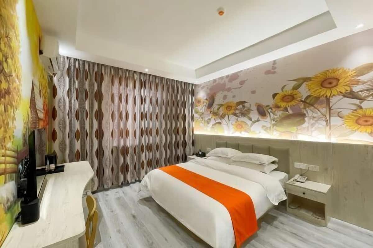 Una habitación de hotel moderna con una cama, un escritorio y una pared decorada con un mural floral.