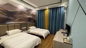 Habitación de hotel con dos camas, un escritorio y un mural grande en la pared.