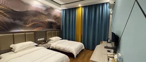 A hotel room with two beds, a desk, and a large wall mural.