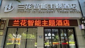 Fachada del Hotel Orchid Intelligent Theme, con un cartel llamativo en inglés y chino.