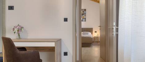 Un dormitorio moderno con cama, mesita de noche y escritorio con silla.