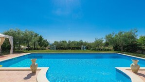 A rectangular swimming pool with a tiled edge, surrounded by a tiled patio. - Ivan & Tina by Interhome (Rovinj)
