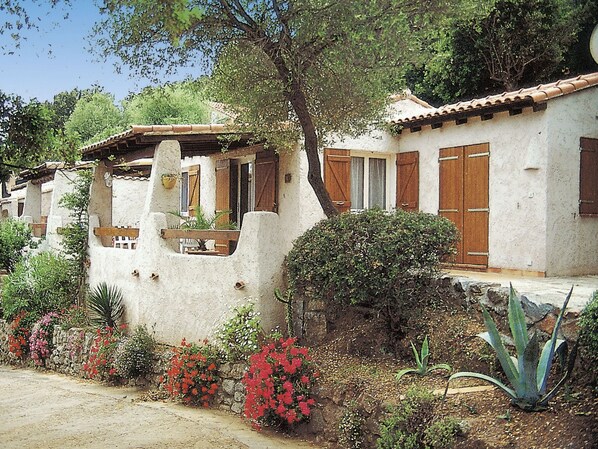 Un bâtiment traditionnel avec un toit en tuiles, une porte en bois et un petit balcon.