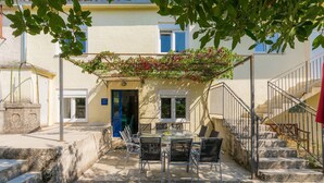 A courtyard with a table and chairs, a blue door, and a staircase. - Danijela by Interhome (Rovinj)