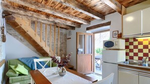 A cozy kitchen with wooden beams, a dining table, and a green sofa. - Pinia I+II by Interhome (Poreč/Kaštelir)