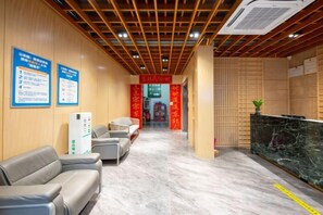 A hotel reception area with a marble floor, seating, and informational posters. - Aige Hotel (Shenzhen Bao'an Fanshen Subway Station) (Shenzhen)
