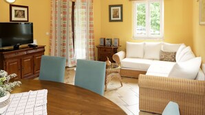 A living room with a television, sofa, chairs, and a dining table. - Vacation home Ana by Interhome (Šibenik)